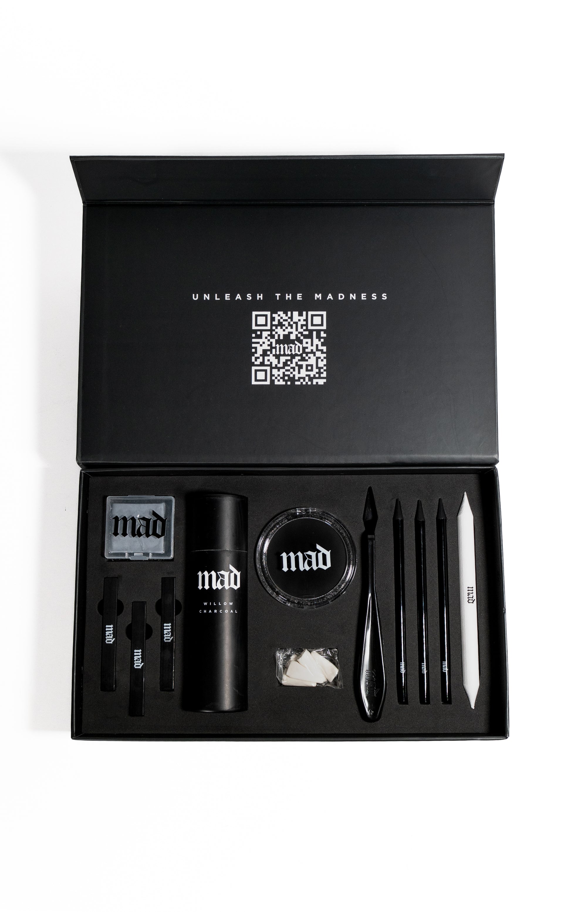 Black gift set with stationery items and 'mad' branding on a white background