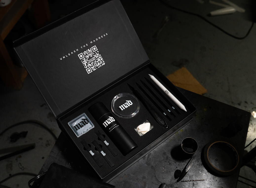 Black box with Art materials and MAD logo on a dark background